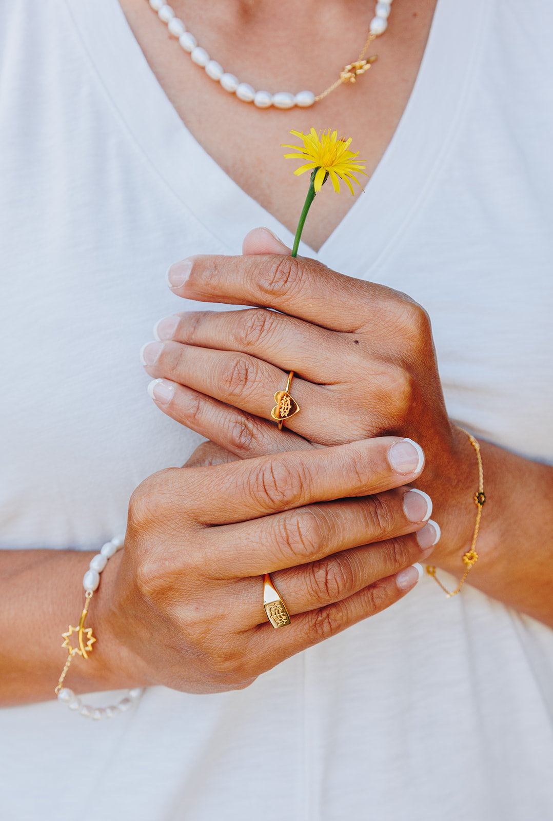 simple gold heart bahai ringstone ring holding yellow dandelion flower