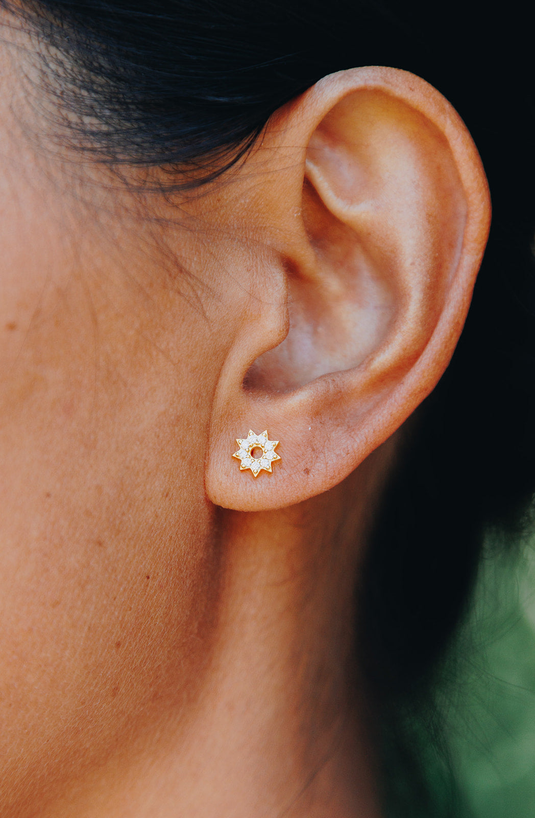 Gold tiny sun stud earrings with nine zircon diamonds.