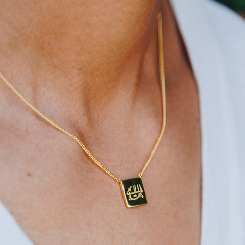 simple gold cushion Baha'i necklace with an engraving of the Greatest Name in Arabic